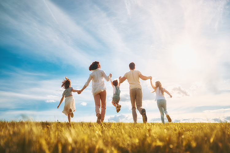 Happy family on summer walk! Mother, father and daughters walking in the Park and enjoying the beautiful nature.